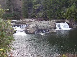 A river with several small waterfalls and rocks.