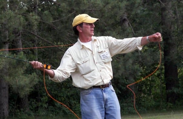 A man in a yellow shirt is holding a fishing rod.